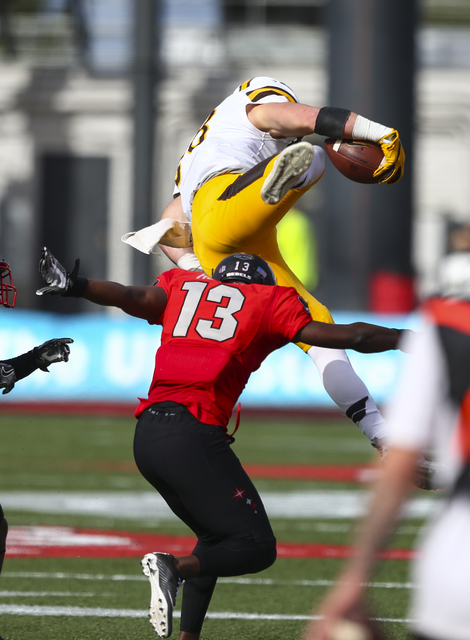 Wyoming tight end Jacob Hollister (88) jumps over UNLV defensive back Tim Hough (13) while running the ball during a football game at Sam Boyd Stadium in Las Vegas on Saturday, Nov. 12, 2016. (Cha ...