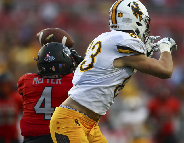 UNLV defensive back Torry McTyer (4) intercepts a pass intended for Wyoming wide receiver Jake Maulhardt (83) during a football game against Wyoming at Sam Boyd Stadium in Las Vegas on Saturday, N ...