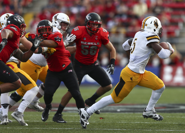 Wyoming running back Brian Hill (5) gets past UNLV defense during a football game at Sam Boyd Stadium in Las Vegas on Saturday, Nov. 12, 2016. UNLV defeated Wyoming 69-66 in triple overtime. Chase ...