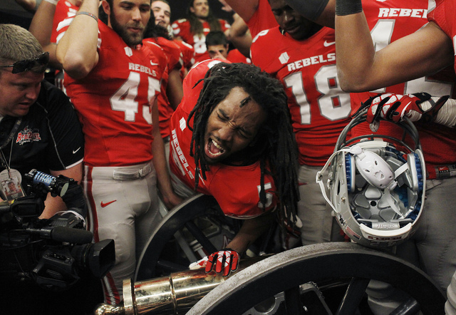 UNLV's Frank Crawford (5) leans over to touch the Fremont Cannon as his teammates celebrate their victory over UNR at Mackay Stadium in Reno on Oct. 26, 2013. (Jason Bean/Las Vegas Review-Journal)