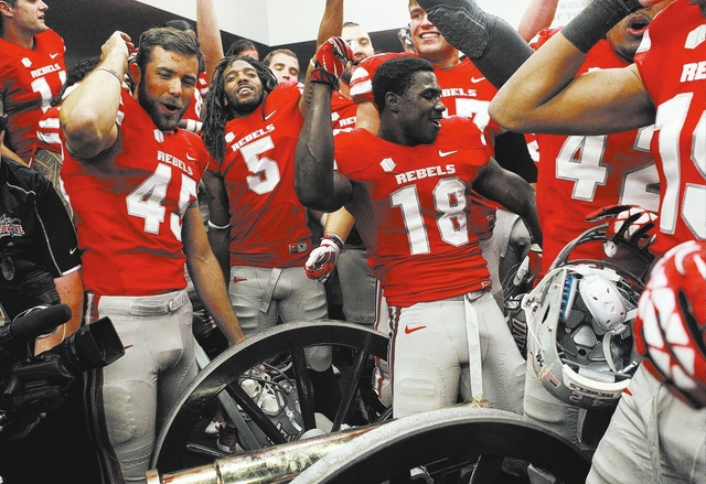 UNLV players dance over the Fremont Cannon as they celebrate their victory over UNR at Mackay Stadium in Reno on Oct. 26, 2013. (Jason Bean/Las Vegas Review-Journal)