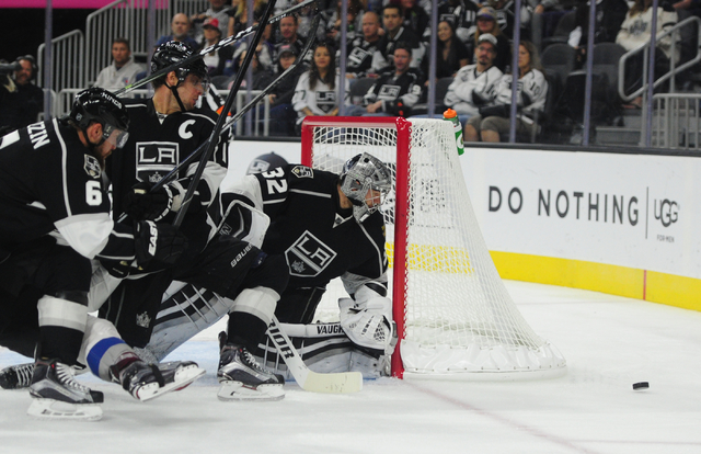 Los Angeles Kings goalie Jonathan Quick (32), defenseman Jake Muzzin (6) and center Anze Kopitar (11) watch the puck bounce off the boards in the second period of their NHL preseason hockey game a ...
