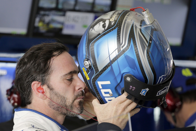 Jimmie Johnson puts on his helmet as he prepares for NASCAR Sprint Cup Series auto practice Saturday, Nov. 19, 2016, in Homestead, Fla. (AP Photo/Terry Renna)