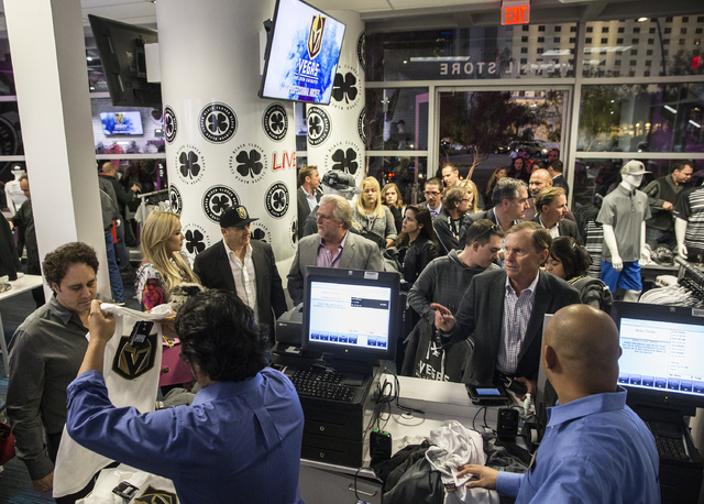 Fans purchase official Golden Knights merchandise at the conclusion of a ceremony to unveil the Las Vegas' NHL expansion franchise's official team name, logos and colors on Tuesday, Nov. 22, 2016, ...