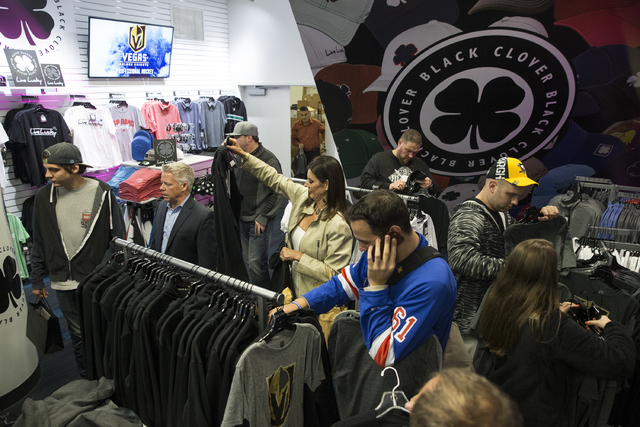 Fans purchase official Golden Knights merchandise at the conclusion of a ceremony to unveil the Las Vegas' NHL expansion franchise's official team name, logos and colors on Tuesday, Nov. 22, 2016, ...