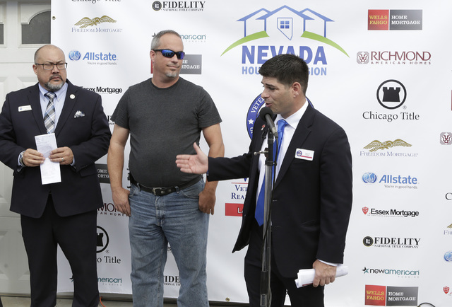 U.S. Army Cpl. Christopher Hudson, center, and Larry DeCoursey, left, listen as Billy Alt, president of the Veterans Association of Real Estate Professionals, speaks Oct. 14, 2016. Hudson received ...