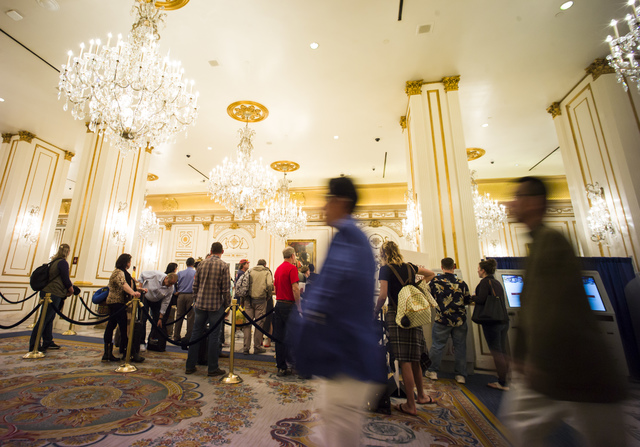 Hotel guests walk through the lobby of the Paris hotel-casino in