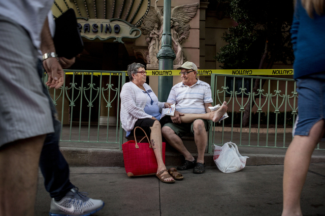 Helene Decary and Jacques Decary, guests of the Paris hotel-casino, sit outside of the establishment while waiting for updates on the power outage on Thursday evening, Nov. 3, 2016 in Las Vegas.   ...
