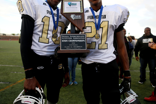 Spring Mountain Eagles hold their trophy after they winning the class 1A state football final neutral playoff game against Pahranagat Valley at Clark High School in Las Vegas, Saturday, Nov. 19, 2 ...