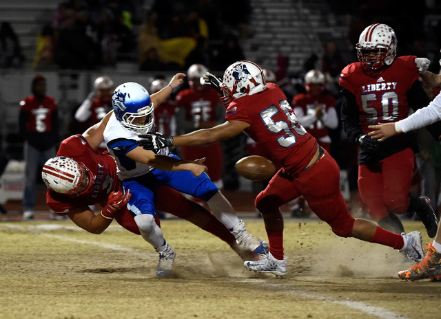 Basic quarterback Rasheem Newsome (8) fumbles the ball under pressure from Liberty during a high school football game at Liberty High School Friday, Nov. 18, 2016, in Henderson. David Becker/Las V ...