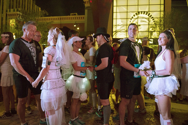 Melanie Correia, right, and Stanley Dymbecki, second from right, of Toronto, Canada, wait to be married during the Rock 'n' Roll Marathon's  “run-thru” weddings at The Park in Las Ve ...