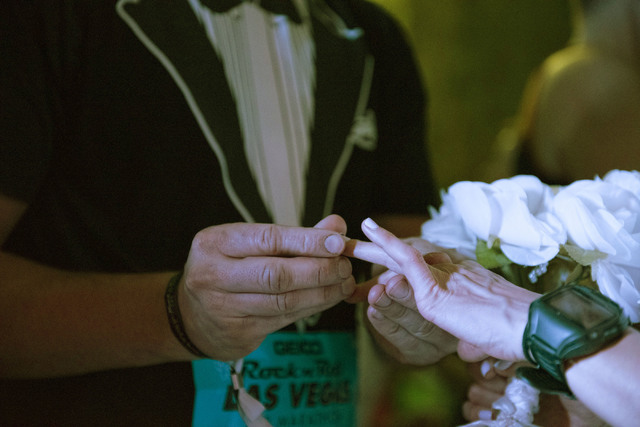 Stanley Dymbecki, left, places a ring on Melanie Correia's finger as they're married during the Rock 'n' Roll Marathon's “run-thru” weddings at The Park in Las Vegas, Sunday, Nov. 13 ...