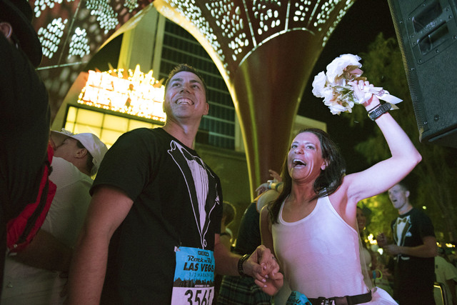 Melanie Correia, right, and Stanley Dymbecki, of Toronto, Canada, are married during the Rock 'n' Roll Marathon's “run-thru” weddings at The Park in Las Vegas, Sunday, Nov. 13, 2016. ...