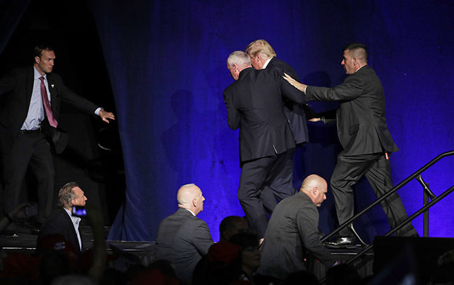 Members of the Secret Service rush Republican presidential candidate Donald Trump off the stage at a campaign rally in Reno, Nev., on Saturday, Nov. 5, 2016. (John Locher/The Associated Press)