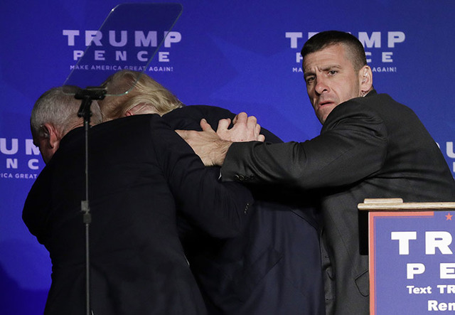 Members of the Secret Service rush  Donald Trump off the stage at a campaign rally in Reno, Nev., on Saturday, Nov. 5, 2016. (John Locher/The Associated Press)