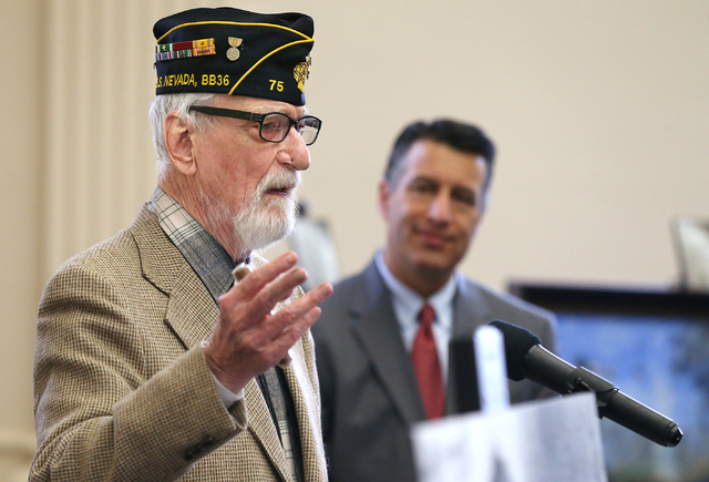 Gov. Brian Sandoval, rear, listens as Pearl Harbor survivor Charles Sehe speaks at the USS Neva ...