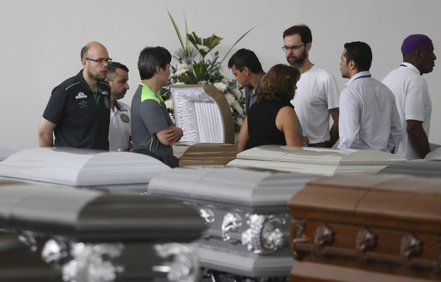 Members of Chapecoense soccer club's board of directors stand in the parking garage of the San Vicente funeral home where coffins containing the remains of the victims of the Colombian air tragedy ...