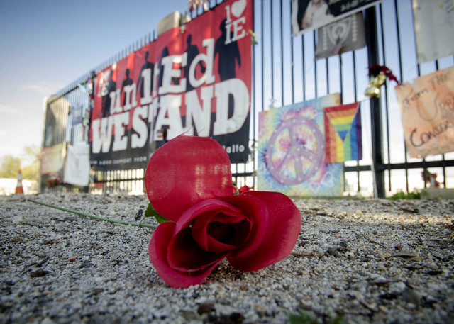 An artificial flower lays in front of memorial items displayed at the Inland Regional Center, the site of last year's terror attack, in San Bernardino, Calif., Thursday Dec. 1, 2016. Friday will m ...