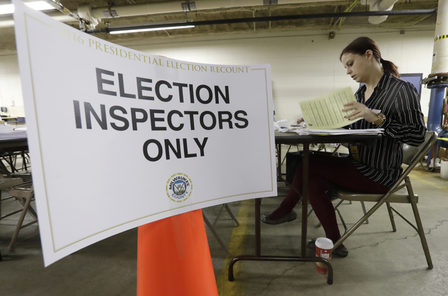 Nicole Kirby looks over results during a statewide presidential election recount Thursday, Dec. 1, 2016, in Milwaukee. The first candidate-driven statewide recount of a presidential election in 16 ...