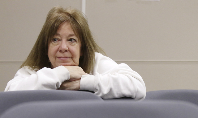 Observer Valery Brussat, of West Bend, leans over another chair to get a closer look of tabulators recounting ballots during a statewide presidential election recount Thursday, Dec. 1, 2016, West ...