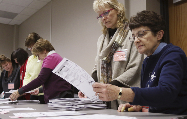 Tabulator Claudette Moll, right, from Farmington, looks over a ballot during a statewide presidential election recount Thursday, Dec. 1, 2016, West Bend, Wis. (John Ehlke/West Bend Daily News via AP)