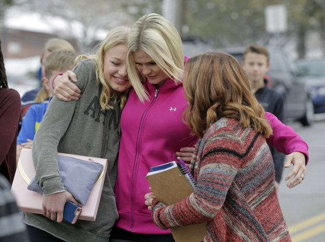 A mother greets her daughter and a friend following a lockdown at Mueller Park Junior High after a student fired a gun into the ceiling Thursday, Dec. 1, 2016, in Bountiful, Utah. (Rick Bowmer/AP)