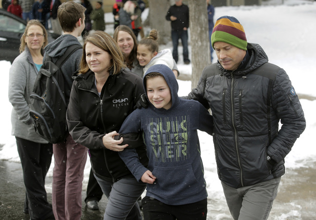 Jessica and David Barlow walk with their son Sam following a lockdown at Mueller Park Junior High after a student fired a gun into the ceiling Thursday, Dec. 1, 2016, in Bountiful, Utah. (Rick Bow ...