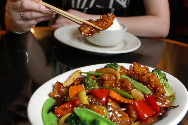 In this July 22, 2004 file photo, Tong Xian Mei, of Ollie's Restaurant, samples from a plate of General Tso's Chicken in New York. Chef Peng Chang-kuei, the chef who has been credited with inventi ...