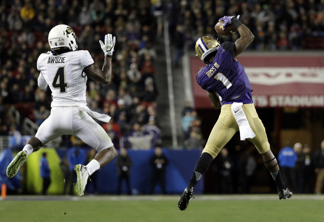Washington wide receiver John Ross (1) catches a pass next to Colorado defensive back Chidobe Awuzie (4), on the way to a touchdown during the second half of the Pac-12 Conference championship NCA ...