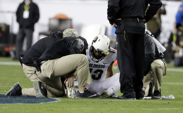 Colorado quarterback Sefo Liufau is attended on the field after an injury during the first half of the Pac-12 Conference championship NCAA college football game against Washington on Friday, Dec.  ...