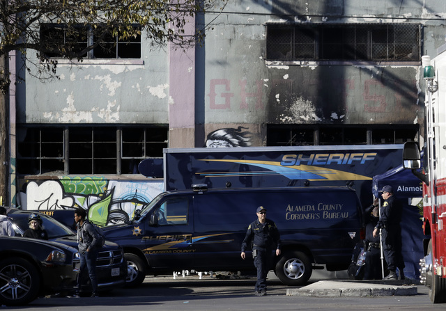 A coroner's van is parked outside of a warehouse after it was destroyed by a fire Saturday, Dec. 3, 2016, in Oakland, Calif. Oakland fire chief Teresa Deloche-Reed said many people were unaccount ...