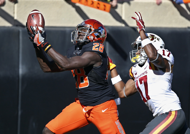 In this Oct. 8, 2016, file photo, Oklahoma State wide receiver James Washington (28) catches a pass in front of Iowa State defensive back Jomal Wiltz (17) in the second quarter of an NCAA college ...