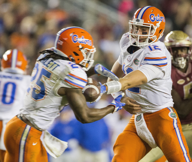Florida quarterback Austin Appleby (12) hands off to running back Jordan Scarlett in the second half of an NCAA college football game against Florida State in Tallahassee, Fla., Saturday, Nov. 26, ...