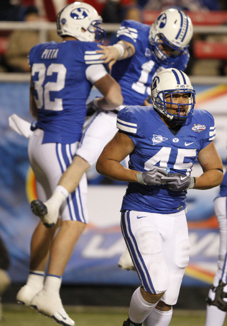 BYU's Harvey Unga (45) trots off the field as teammates Dennis