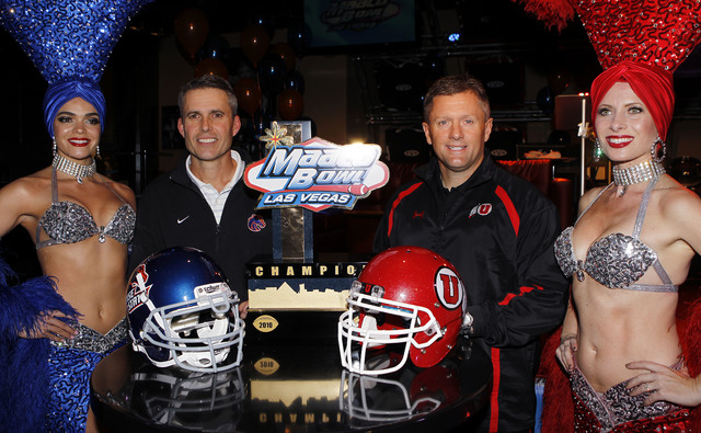 Showgirl Porsha Revesz, left, Boise State coach Chris Petersen, Utah coach Kyle Whittingham and showgirl J.P. Howard pose for photos during a news conference Sunday, Dec. 19, 2010, in Las Vegas. ( ...
