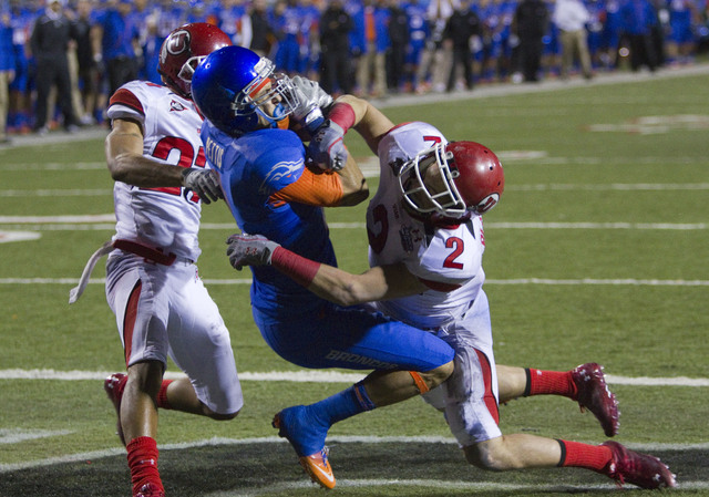 Boise State wide receiver Austin Pettis catches the ball in the end zone while being tackled by Utah defensive back Brian Blechen (2) and defensive back Brandon Burton (27) during the second half  ...