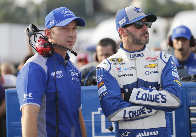 Jimmie Johnson, right, waits with crew chief Chad Knaus as they wait for NASCAR Sprint Cup qualifying at Richmond International Raceway in Richmond, Va., Friday, Sept. 9, 2016. (AP Photo/Steve Helber)