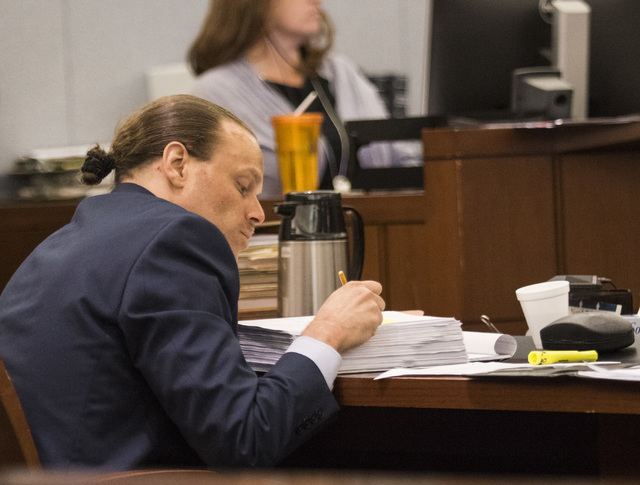 Defendant Norman Belcher looks over his notes during his death penalty trial at the Regional Justice Center in Las Vegas, on Friday, Dec. 2, 2016. Belcher, 41, is charged with killing his grade-sc ...