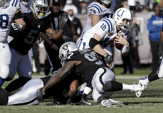 Indianapolis Colts quarterback Andrew Luck (12) is tackled against the Oakland Raiders during the first half of an NFL football game in Oakland, Calif., Saturday, Dec. 24, 2016. (AP Photo/Marcio J ...