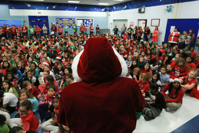 Eric Johnson as Santa talks to students before giving them gifts at C.T. Sewell Elementary School in Henderson on Friday, Dec. 16, 2016. The gifts were donated by Bob and Sandy Ellis, who have don ...