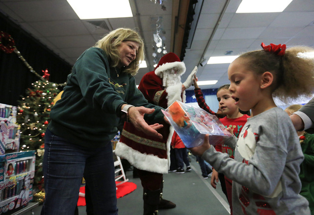 District Court Judge Susan Johnson hands out gifts to students at C.T. Sewell Elementary School in Henderson on Friday, Dec. 16, 2016. The gifts were donated by Bob and Sandy Ellis, who have donat ...