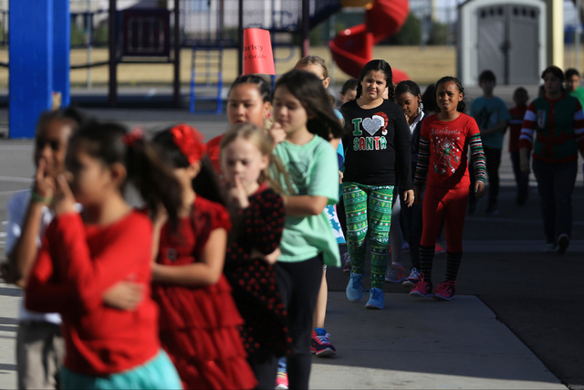 Students line up to enter the cafeteria of C.T. Sewell Elementary School to receive donated gifts in Henderson on Friday, Dec. 16, 2016. The gifts were donated by Bob and Sandy Ellis, who have don ...