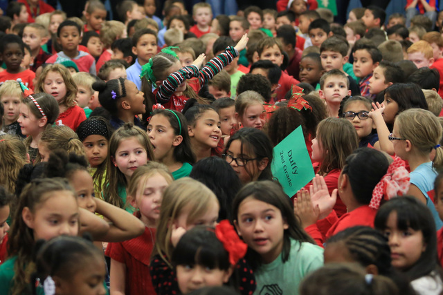 A young girl dabs as Santa talks to students before giving them gifts at C.T. Sewell Elementary School in Henderson on Friday, Dec. 16, 2016. The gifts were donated by Bob and Sandy Ellis, who hav ...