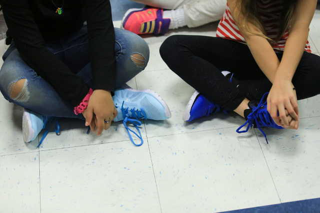 Students wear new shoes while listening to Santa speak at C.T. Sewell Elementary School in Henderson on Friday, Dec. 16, 2016. Gifts for every student at the school were donated by Bob and Sandy E ...