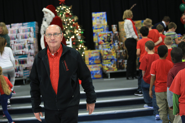 Bob Ellis watches walks between students as they line up to receive gifts at C.T. Sewell Elementary School in Henderson on Friday, Dec. 16, 2016. The gifts were donated by Bob and Sandy Ellis, who ...
