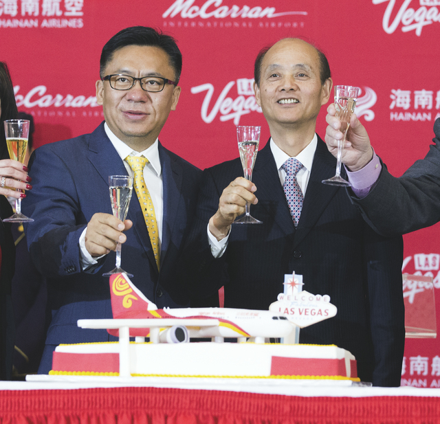 Hou Wei, senior VP of Hainan Airlines, and Luo Linquan, consul general for the People's Republic of China in San Francisco, toast during a inaugural flight reception at McCarran International Airp ...