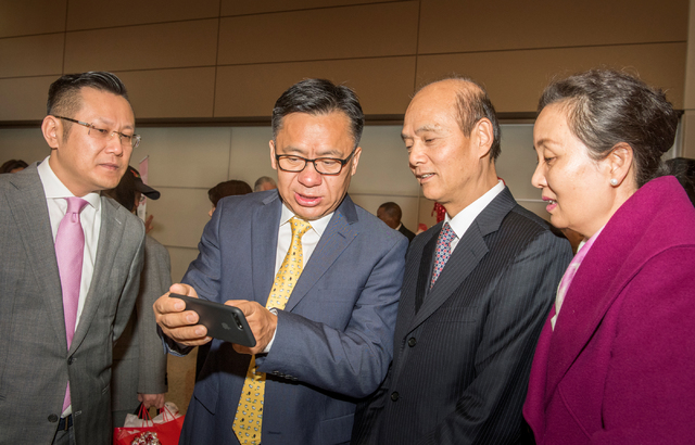 Hou Wei, second from left, senior vice president of Hainan Airlines shows a photo to Ambassador Luo LiQuan of the San Francisco Consulate of the People's Republic of China, and others, as they cel ...