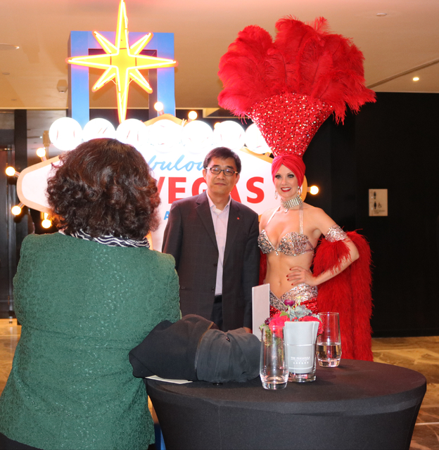 Chinese people in the travel industry take turns posing with Las Vegas showgirl Jennifer Autry during a launch party for Hainan Airlines' nonstop service from Beijing to Las Vegas. Hainan Airlines ...