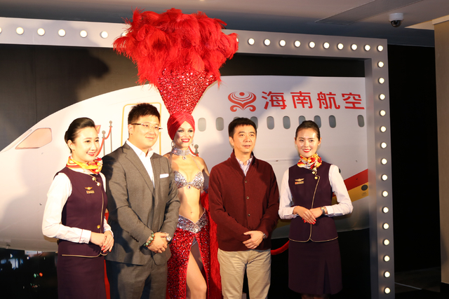 Hainan Airlines flight attendants April Lu, left, and Lavin Yuan pose with Wang Yi Bin, left, and Chen Qing Long, as well as with Las Vegas showgirl Laura during a launch party for Hainan Airlines ...