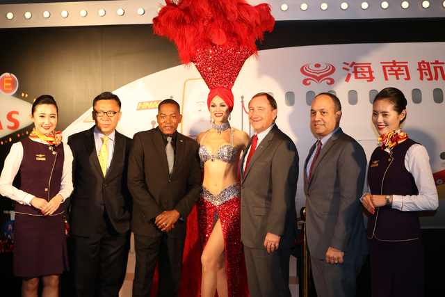 Hainan Airlines flight attendants April Lu, left, and Lavin Yuan pose with Hou Wei, left, senior vice president of Hainan Airlines, Commissioner Lawrence Weekly, Las Vegas showgirl Laura, Las Vega ...